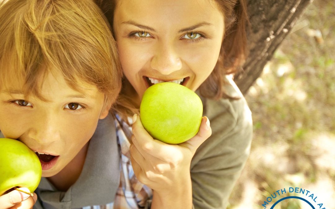 A mom and her son eating apples