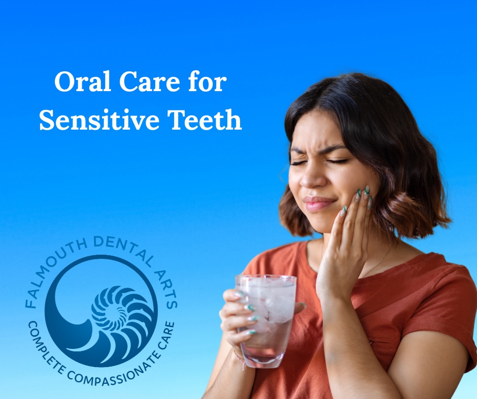 Woman wincing from sensitive teeth with glass of water in her hand