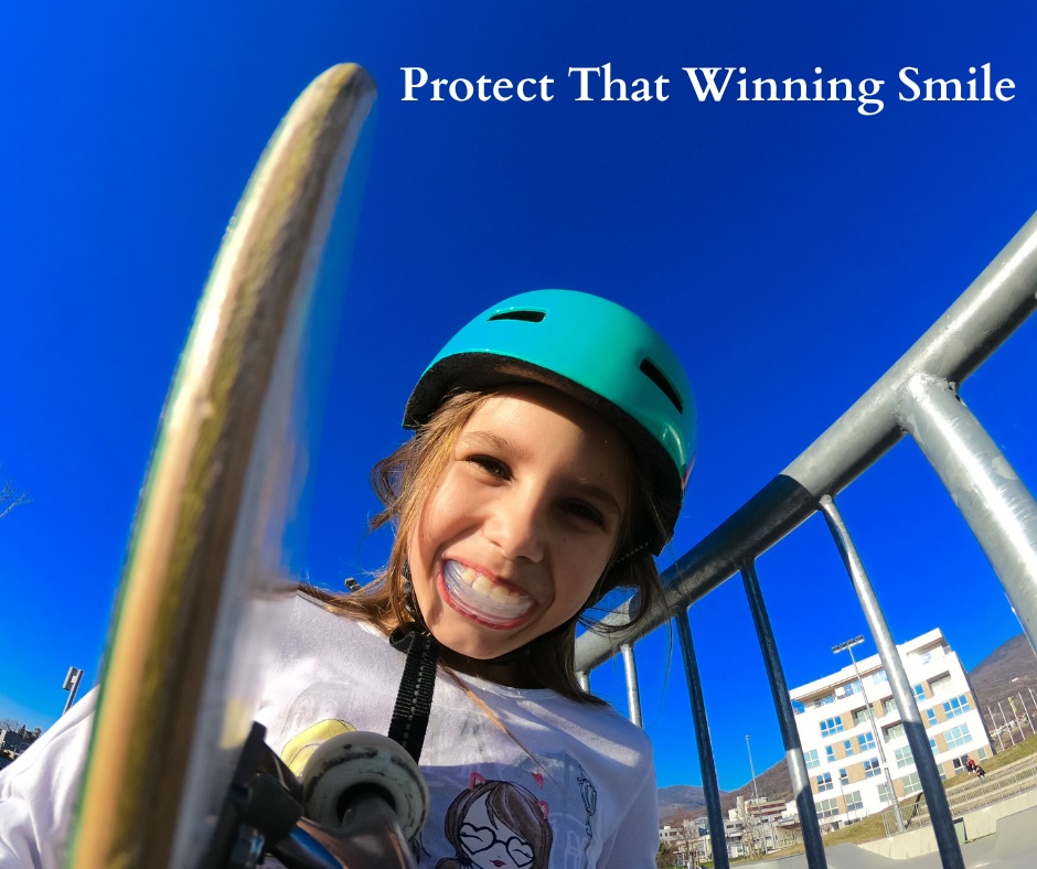 Girl smiling with mouthguard in, helmet on and skateboard